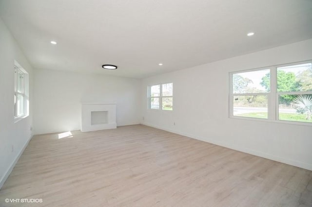 7645 58th Ave, Vero Beach, FL 32967 - unfurnished living room with light wood-type flooring, recessed lighting, and baseboards