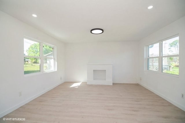 7645 58th Ave, Vero Beach, FL 32967 - unfurnished living room with baseboards, recessed lighting, and light wood finished floors