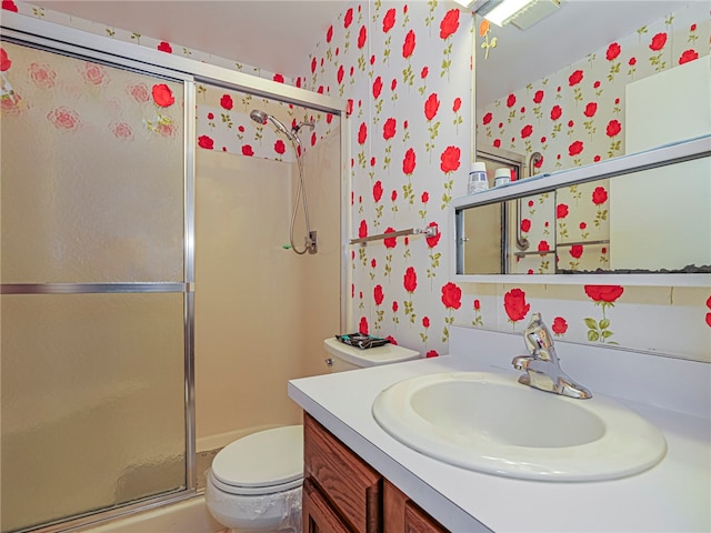 full bathroom featuring a shower stall, toilet, and vanity