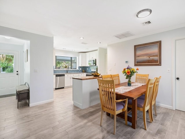 dining room featuring light wood-type flooring, baseboards, and visible vents