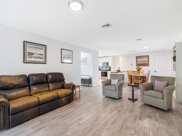 living area featuring light wood-style flooring and visible vents