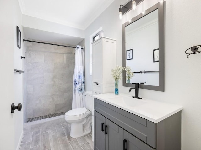 full bath featuring toilet, a tile shower, vanity, and crown molding