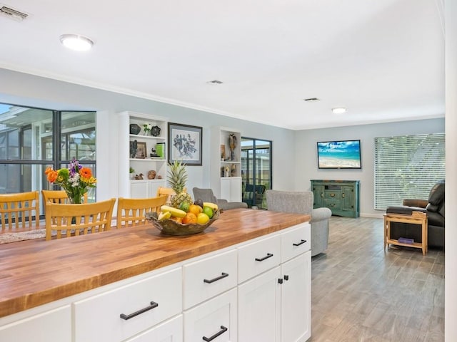 kitchen featuring open floor plan, wooden counters, light wood finished floors, and visible vents