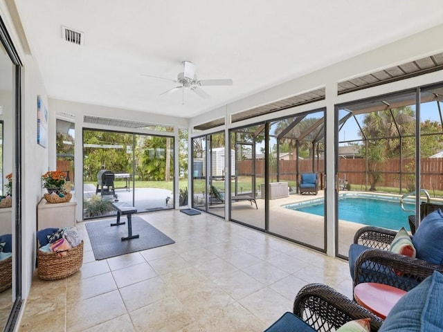 sunroom / solarium featuring ceiling fan, visible vents, and a healthy amount of sunlight