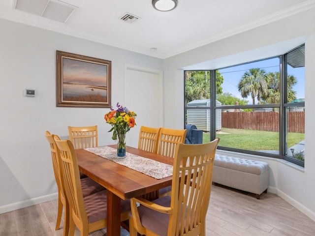 dining space featuring light wood-type flooring, visible vents, and baseboards