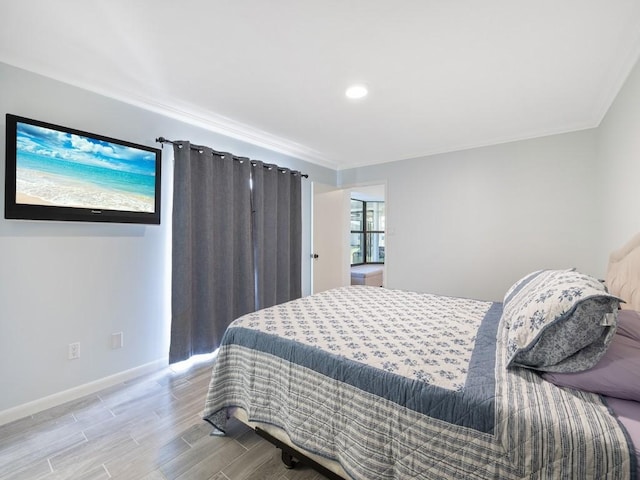 bedroom with ornamental molding, light wood-type flooring, and baseboards