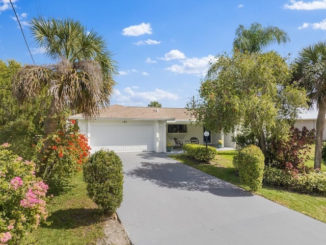 view of front of property with concrete driveway, an attached garage, and stucco siding