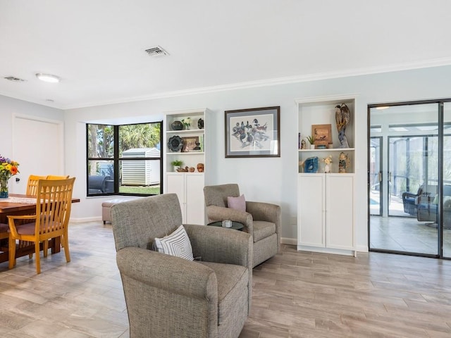 living room featuring ornamental molding, visible vents, and light wood-style floors