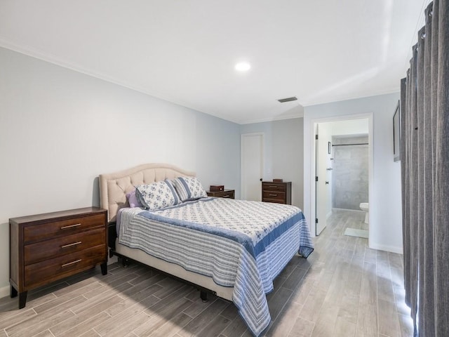 bedroom featuring crown molding, visible vents, wood tiled floor, connected bathroom, and baseboards