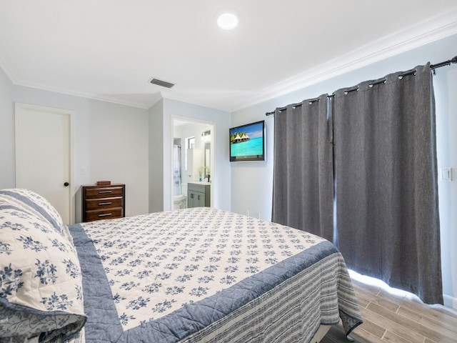 bedroom with ornamental molding, wood tiled floor, visible vents, and connected bathroom