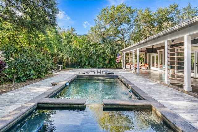 view of pool with an in ground hot tub, french doors, a patio, and ceiling fan