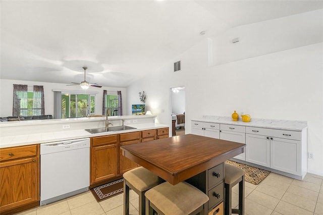 kitchen featuring visible vents, a sink, white dishwasher, light countertops, and lofted ceiling