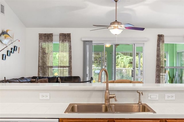 kitchen with tile countertops, a healthy amount of sunlight, open floor plan, and a sink