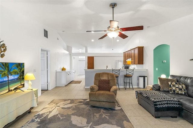 living area featuring ceiling fan, visible vents, arched walkways, and light tile patterned flooring