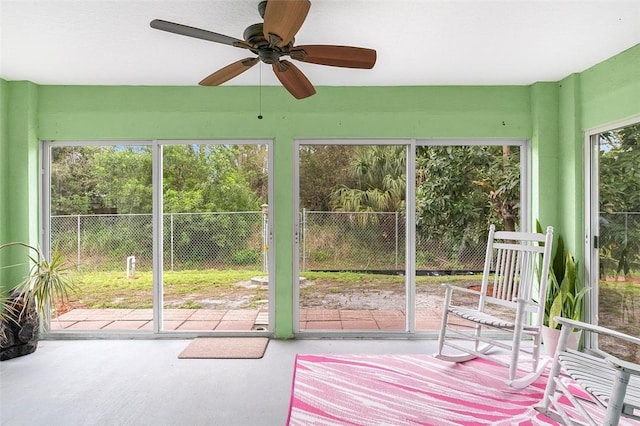 unfurnished sunroom featuring a ceiling fan