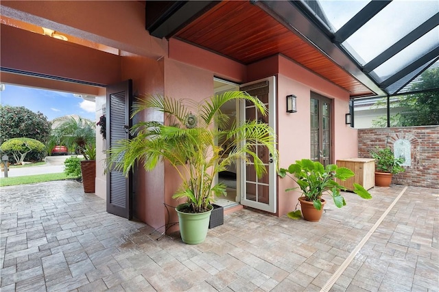 view of patio featuring glass enclosure