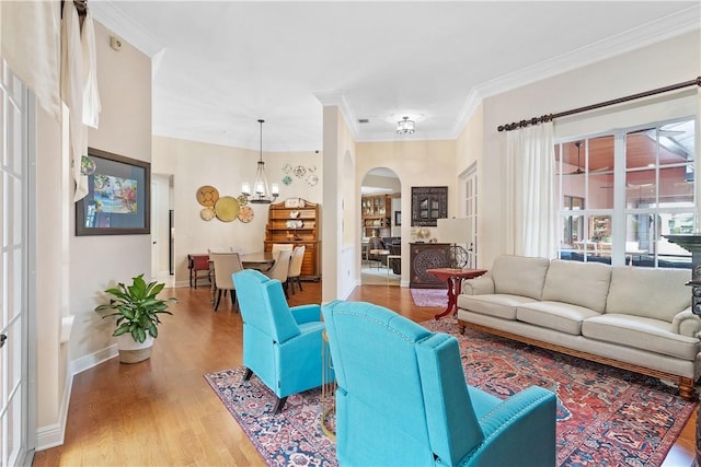 living room featuring crown molding, wood-type flooring, and a notable chandelier