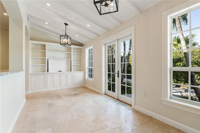 interior space with a chandelier, french doors, lofted ceiling with beams, and plenty of natural light