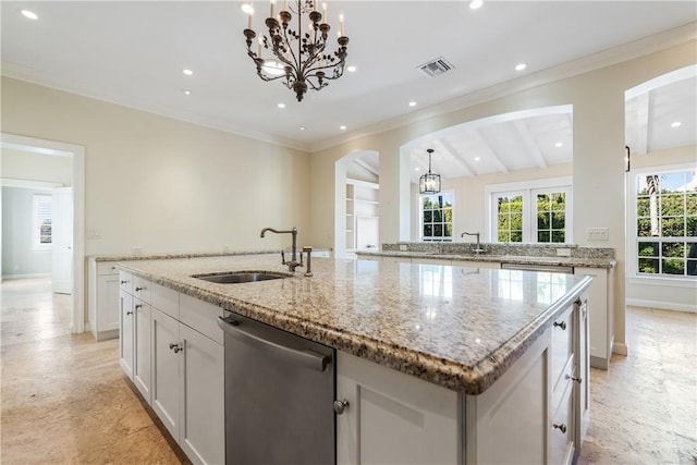 kitchen featuring a kitchen island with sink, sink, dishwasher, white cabinetry, and hanging light fixtures