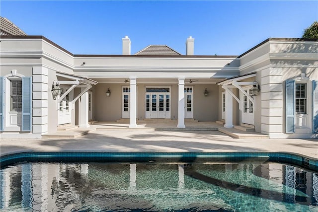 back of property with ceiling fan and a patio area