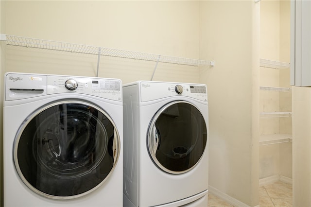 laundry room with washing machine and dryer and light tile patterned flooring