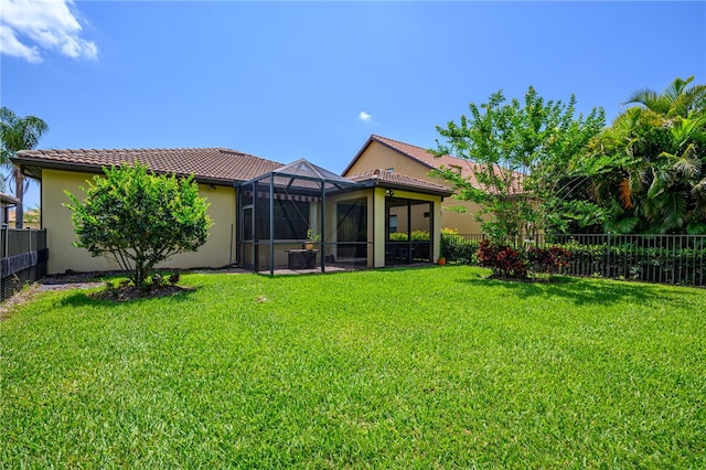 rear view of house featuring a lanai and a yard