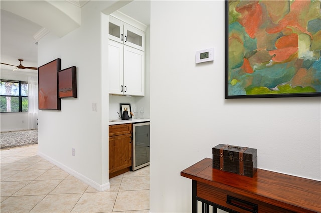 kitchen with white cabinets, light tile patterned flooring, ceiling fan, and wine cooler