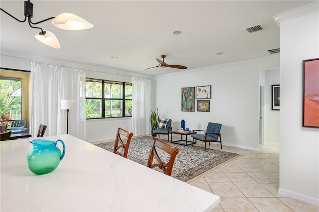 tiled dining space featuring ornamental molding and ceiling fan