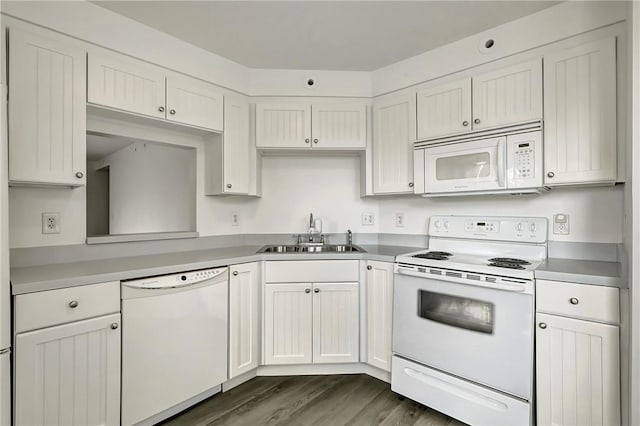 kitchen featuring white appliances, white cabinets, dark wood-style flooring, light countertops, and a sink