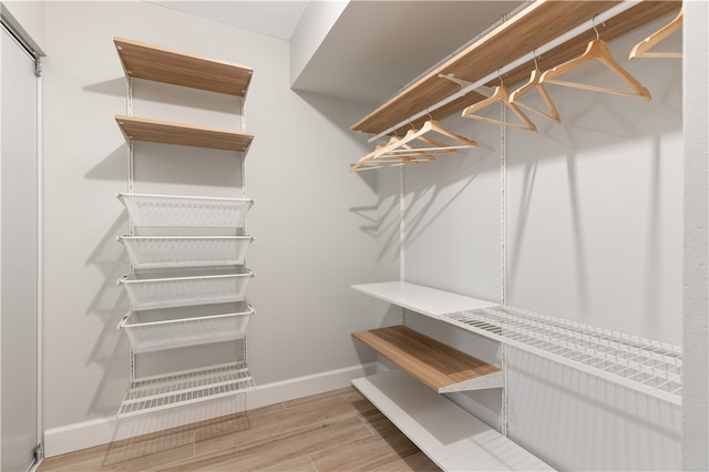 walk in closet with light wood-type flooring