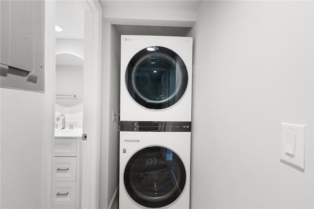 laundry area featuring sink and stacked washer and clothes dryer