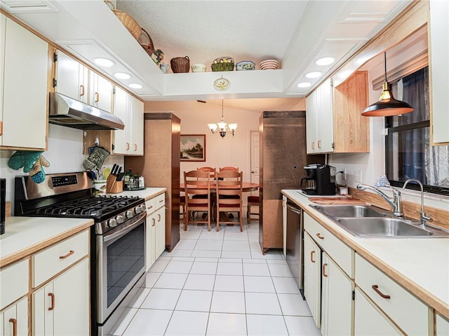 113 Larchmont Ter, Sebastian, FL 32958 - kitchen with under cabinet range hood, stainless steel appliances, a sink, light tile patterned floors, and a chandelier