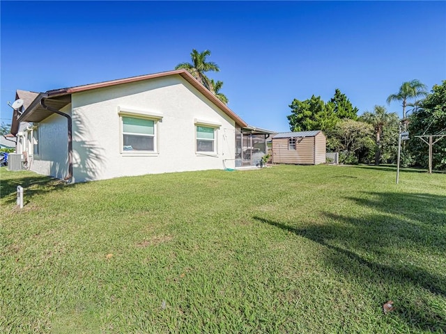 113 Larchmont Ter, Sebastian, FL 32958 - back of property featuring stucco siding, a shed, an outbuilding, a lawn, and central AC