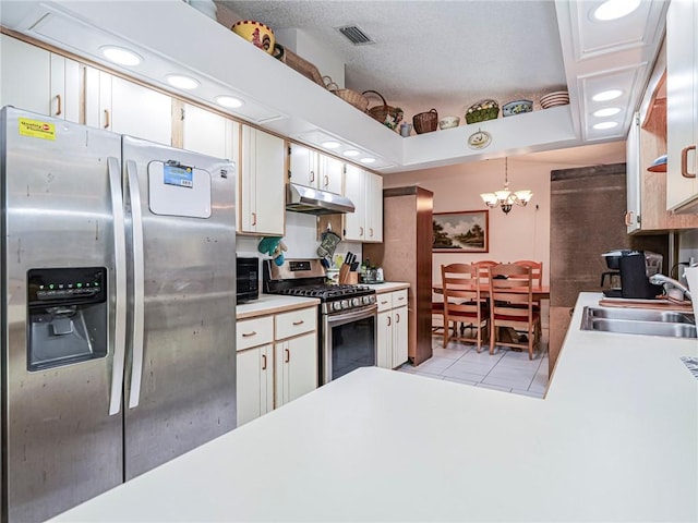 113 Larchmont Ter, Sebastian, FL 32958 - kitchen featuring stainless steel appliances, under cabinet range hood, a sink, light tile patterned floors, and white cabinetry
