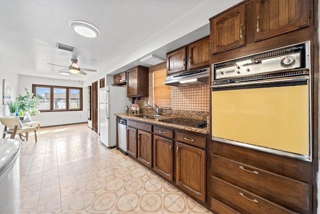 kitchen featuring wall oven, under cabinet range hood, black electric cooktop, a sink, and stainless steel dishwasher