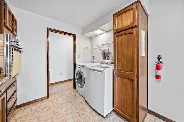 laundry area with washer and clothes dryer, baseboards, and light floors