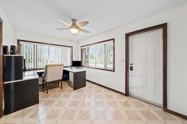 office featuring a ceiling fan and baseboards