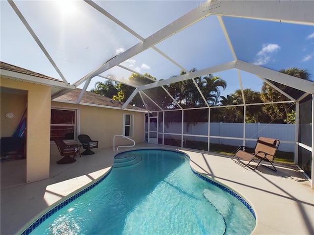 view of swimming pool with a patio area and a lanai