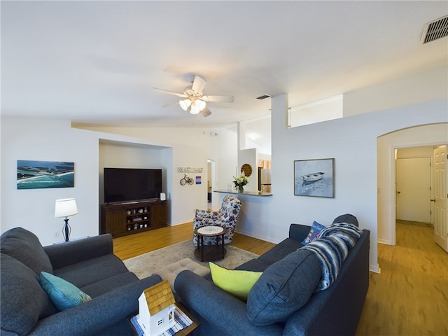 living room featuring ceiling fan, lofted ceiling, and light wood-type flooring