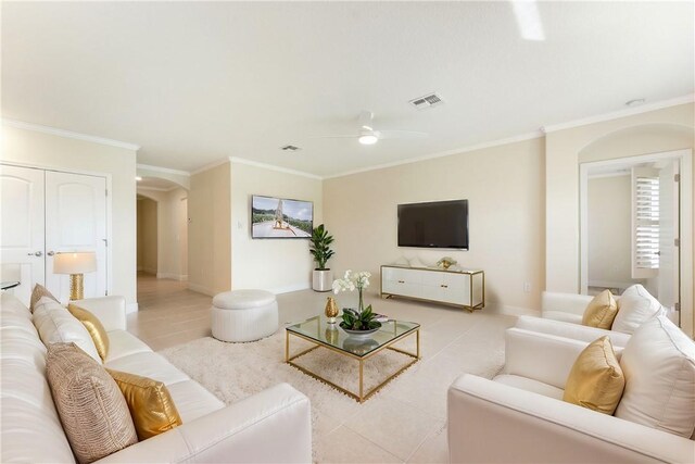 living room with light tile patterned flooring, ceiling fan, and ornamental molding