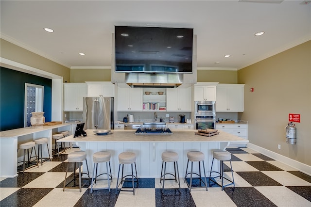 kitchen with stainless steel appliances, white cabinetry, a breakfast bar, and crown molding