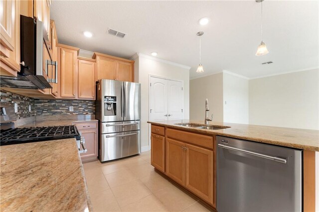 kitchen featuring a center island with sink, hanging light fixtures, sink, light brown cabinets, and appliances with stainless steel finishes