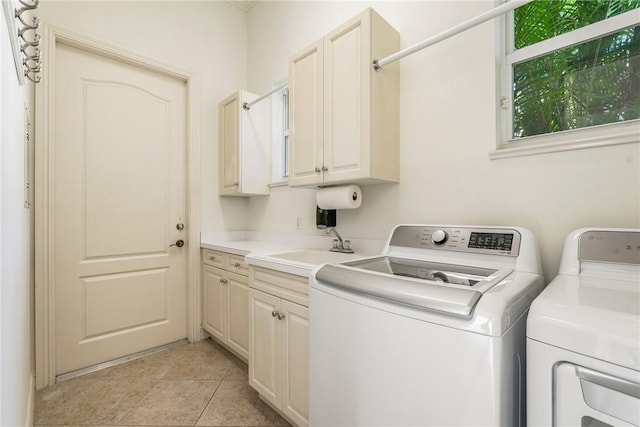 laundry room featuring light tile patterned flooring, cabinet space, independent washer and dryer, and a sink