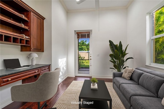 office with built in desk, crown molding, baseboards, and dark wood-style flooring