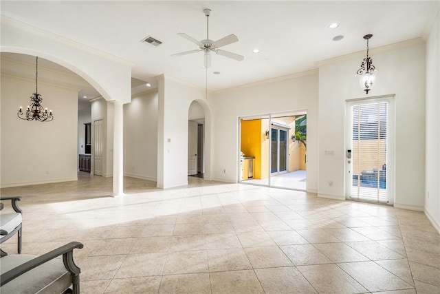 unfurnished living room featuring visible vents, baseboards, ceiling fan, ornamental molding, and arched walkways