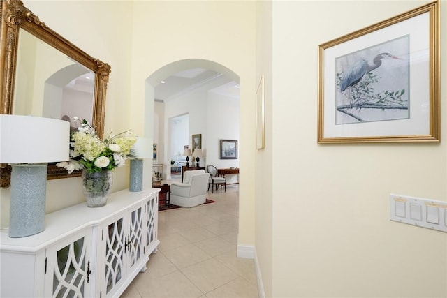 hall featuring crown molding and light tile patterned flooring