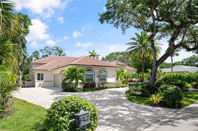 540 Marbrisa Dr, Vero Beach, FL 32963 - mediterranean / spanish-style house with a tiled roof, a chimney, an attached garage, stucco siding, and decorative driveway