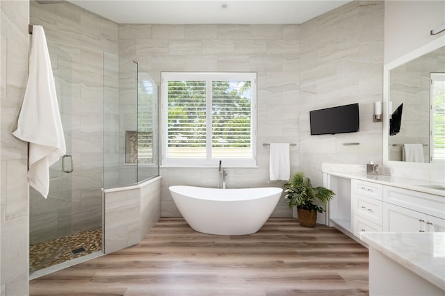 540 Marbrisa Dr, Vero Beach, FL 32963 - full bath with a freestanding bath, wood finished floors, vanity, tile walls, and a stall shower