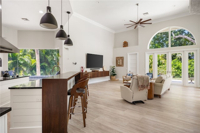 540 Marbrisa Dr, Vero Beach, FL 32963 - living area featuring light wood-style floors, ceiling fan, a towering ceiling, ornamental molding, and visible vents
