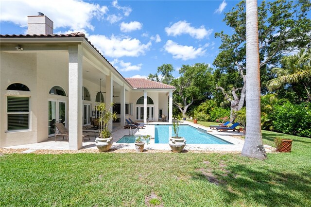 540 Marbrisa Dr, Vero Beach, FL 32963 - rear view of house featuring a patio area, a tiled roof, a chimney, and a yard
